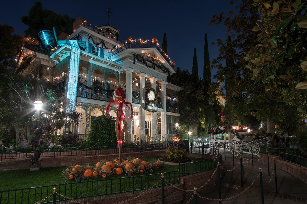 The Haunted Mansion at Disneyland decorated with pumpkins, orange lights and other "The Nightmare Before Christmas" items.