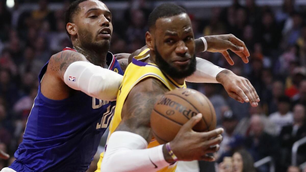 Lakers forward LeBron James spins to the basket against Clippers forward Mike Scott during the game Thursday night.