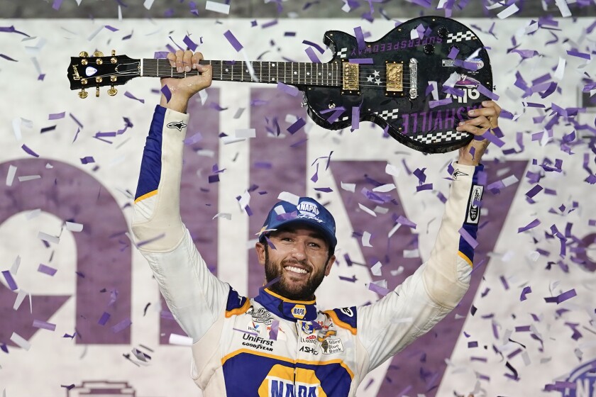 Chase Elliott holds the guitar presented to him after winning a NASCAR Cup Series auto race Sunday, June 26, 2022, in Lebanon, Tenn. (AP Photo/Mark Humphrey)
