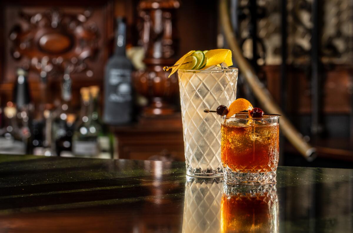 Two cocktails on a wooden bar counter