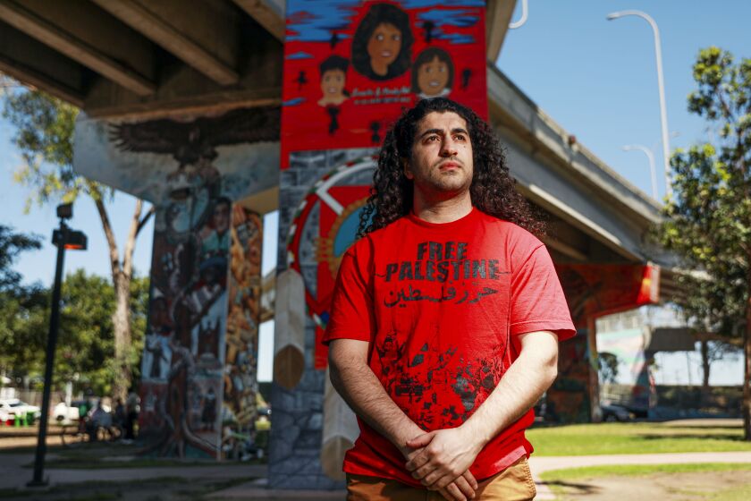 Ali-Reza Torabi stands in Chicano Park area of San Diego, CA on Saturday, Spetember 4, 2021. Torabi was in the sixth grade when two planes slammed into the Twin Towers in New York City on Sept. 11, 2001. Despite living almost 3,000 miles away in San Diego, Torabi saw his world upended."As an undocumented, Middle Eastern individual, there was pre-9/11 life and post-9/11 life,".(Photo by Sandy Huffaker for The Los Angeles Times)