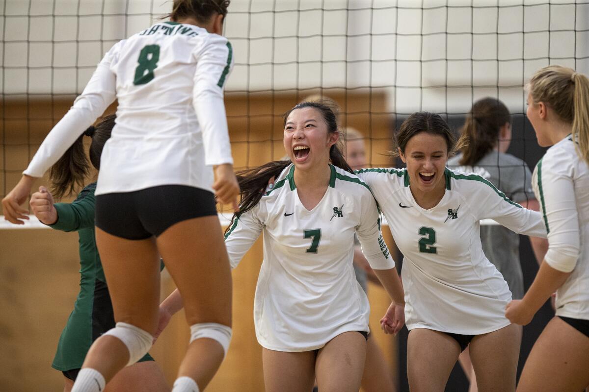 Sage Hill's Brooke Thomassen (8), left, Sophie Wang (7) and Audrey McGuff (2) celebrate winning a point.