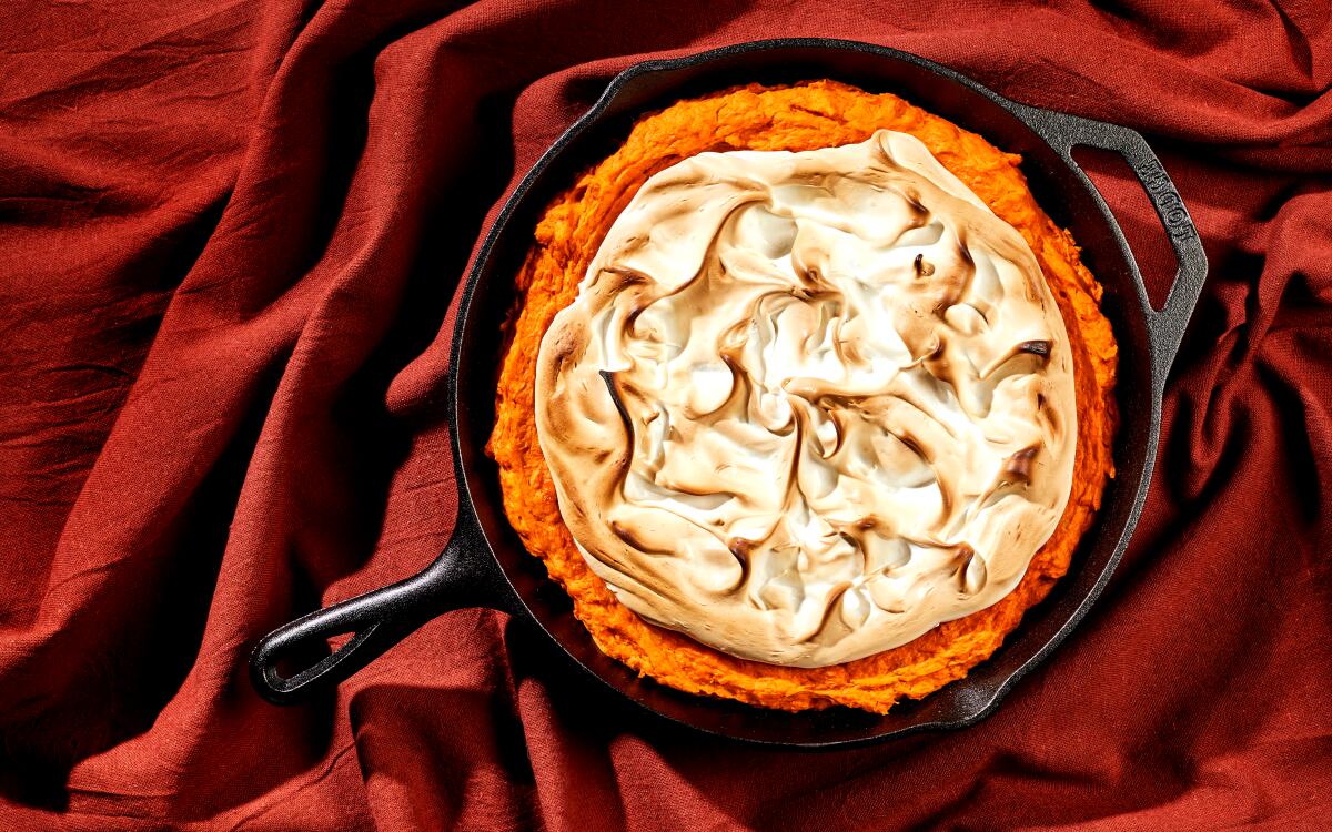 A sweet potato casserole topped with meringue in a cast-iron skillet