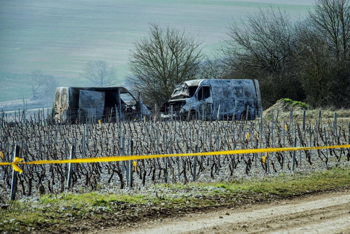 The burned-out remains of two vans that had been carrying millions of dollars in jewels sit on the road a few miles from where they were highjacked in France.