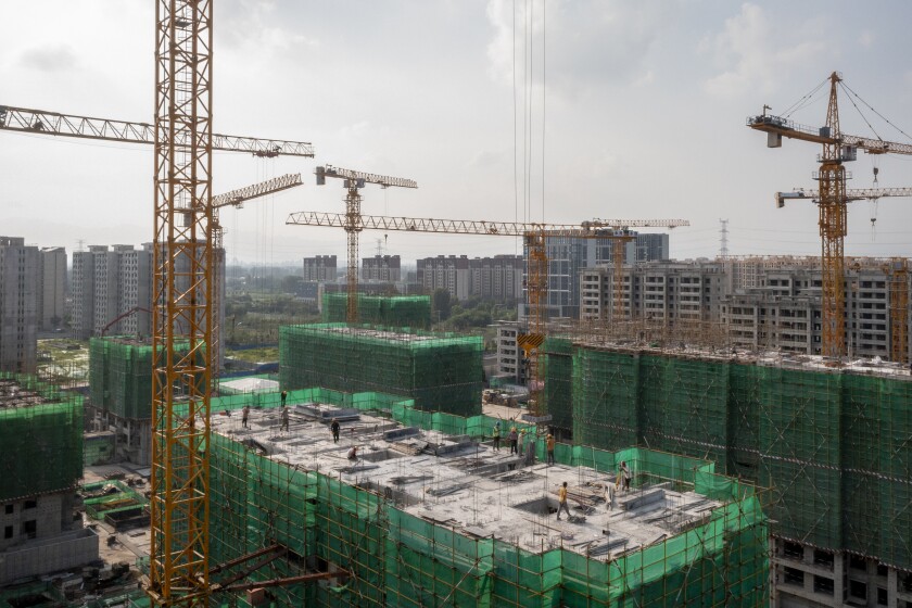 A construction crane towers over an unfinished building