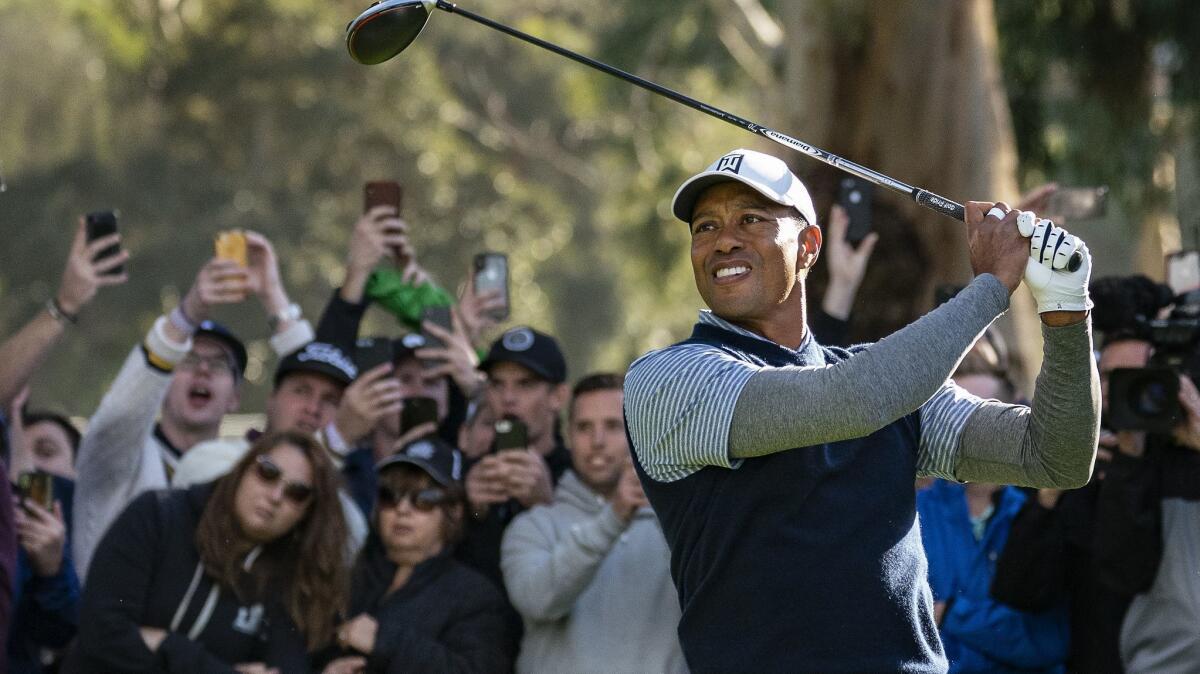 Tiger Woods watches his tee shot on the 11th hole during his third round of the Genesis Open at Riviera Country Club on Saturday in Pacific Palisades. He made an eagle on the hole.