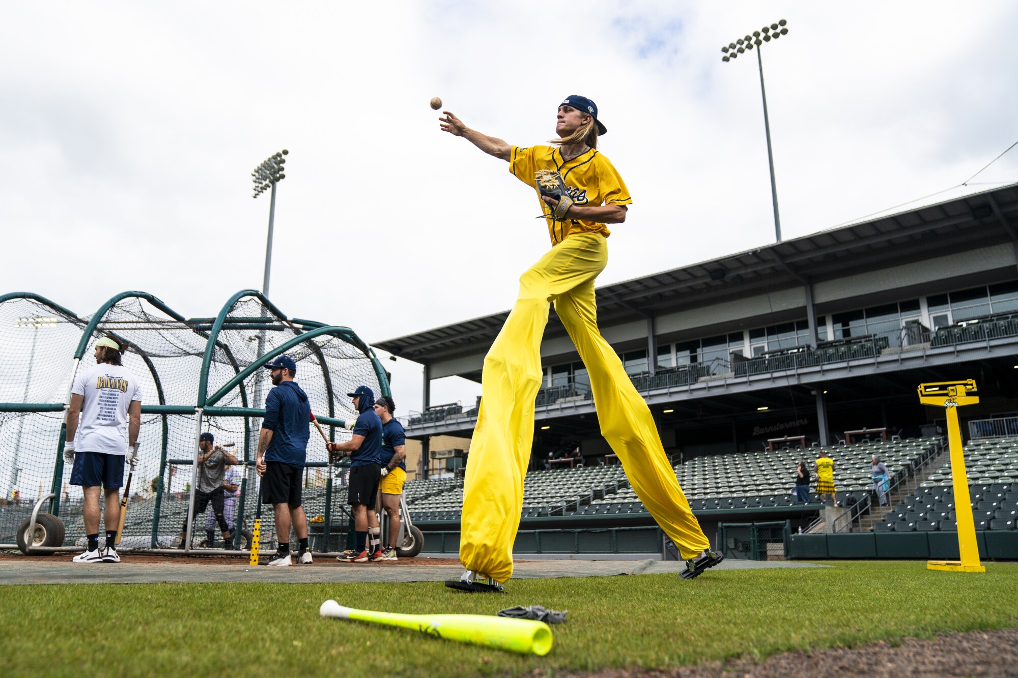 Savannah Bananas player Jacob Teston warms up while pitching on stilts during before a game.