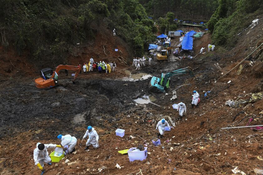 FILE - In this photo released by Xinhua News Agency, search and rescuer workers conduct search operations at the China Eastern flight crash site in Tengxian County on March 26, 2022, in southern China's Guangxi Zhuang Autonomous Region. Experts still are investigating the cause of the crash of a China Eastern Airlines jetliner that plunged into a mountainside one year ago, killing more than hundred people aboard, the government said on Monday, March 20, 2023. (Lu Boan/Xinhua via AP, File)