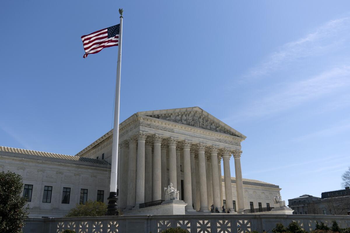The United States flag waving in the wind outside the Supreme Court