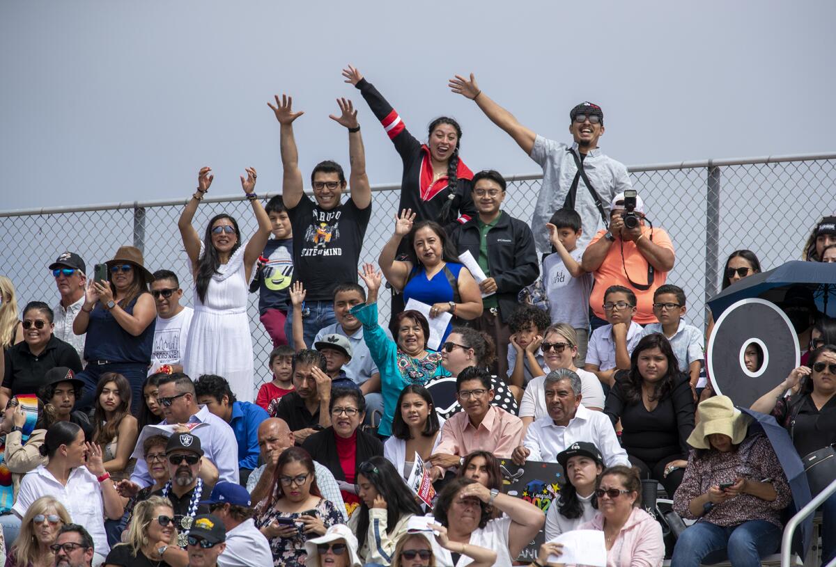 A family waves to their graduate at Estancia High School on Thursday in Costa Mesa.
