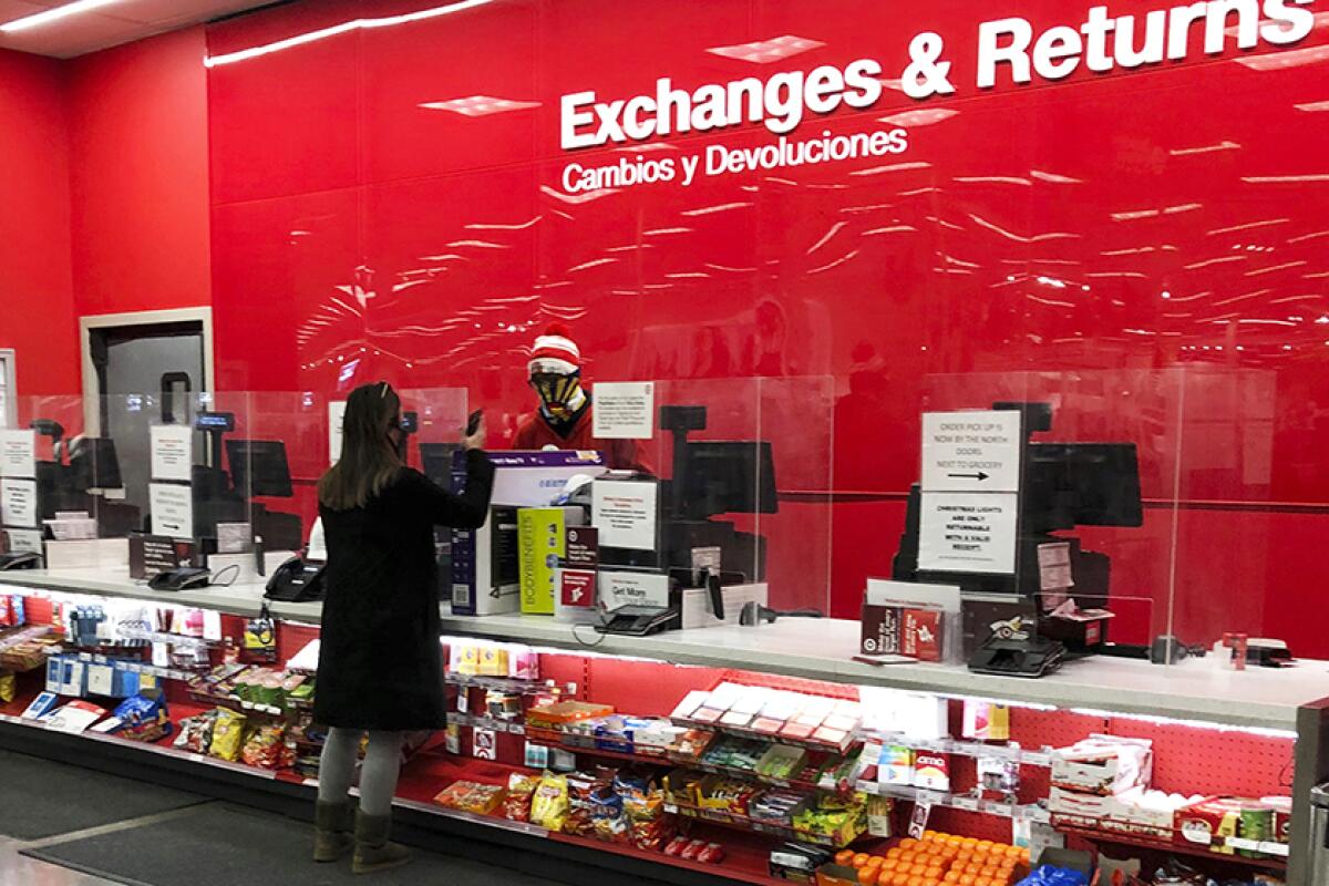 A customer speaks to a worker at the returns counter inside a Target store.