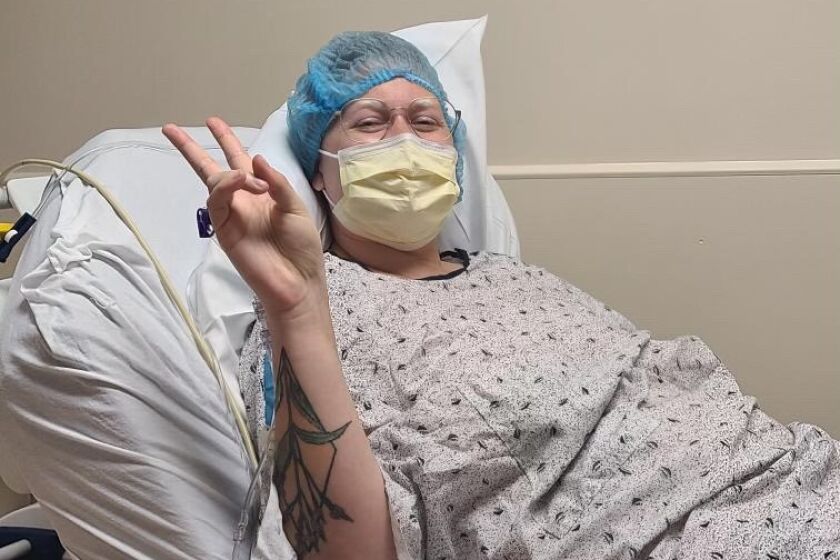 A woman poses for a photo before a surgery.