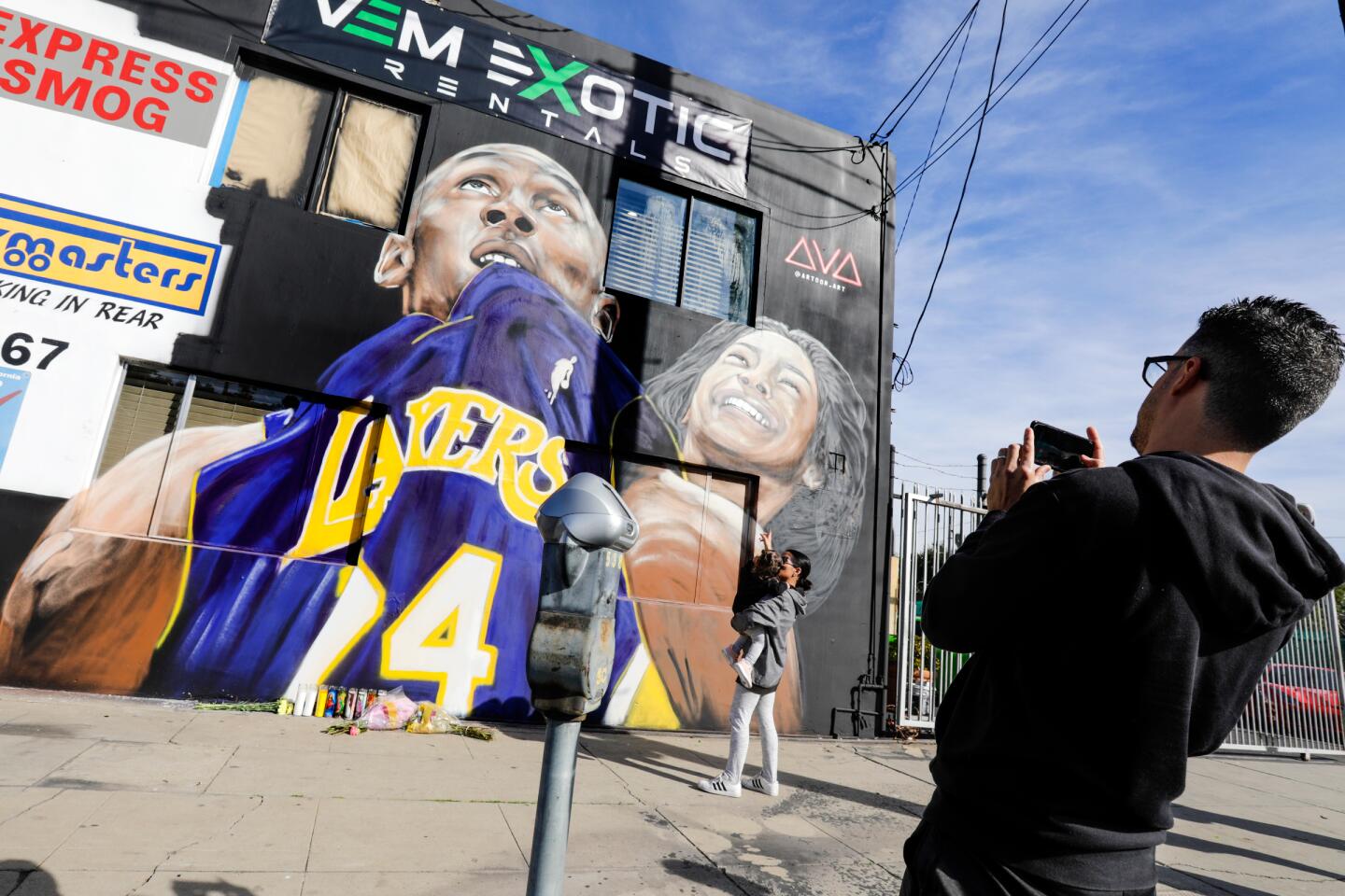 Uziel Colon takes a photo of his wife, Maria Home, and daughter Lena with a mural created to honor Kobe Bryant and his 13-year-old daughter Gianna. The mural is by Art Gozukuchikyan on the side of VEM Exotic Rentals on Ventura Boulevard in Studio City.