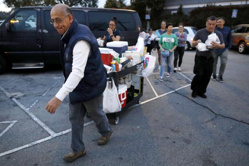 LOS ANGELES, CALIF. -- THURSDAY, FEBRUARY 27, 2020: Customers could not wait for Andres Santos, 59, an elotero (corn man) leaving Highland Park after 20 + years, to get to his spot at Figueroa and 57th Street, to purchase his corn in Los Angeles, Calif., on Feb. 27, 2020. He is well known in the community for his corn and esquite, and has seen the neighborhood change over decades. He has tried to adapt and earned a living selling corn on the street. Now, he's returning to Mexico to start over. (Gary Coronado / Los Angeles Times)