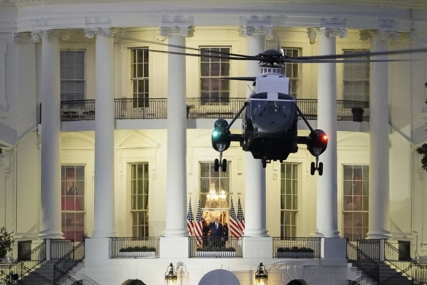 WASHINGTON, DC - OCTOBER 05: U.S. President Donald Trump stands on the Blue Room Balcony as Marine One, takes off from the South Lawn of the White House on October 5, 2020 in Washington, DC. Trump returned to the White House after being treated for Covid-19 at Walter Reed National Military Medical Center since Friday evening. (Photo by Drew Angerer/Getty Images)