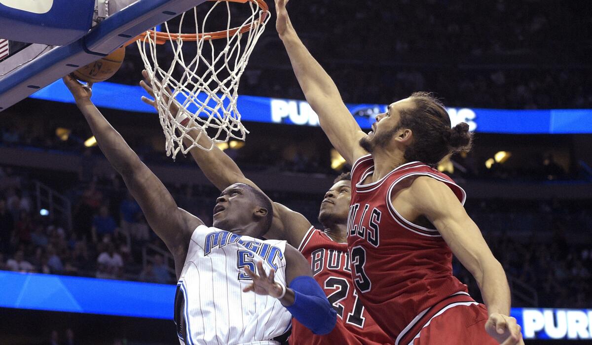 Magic guard Victor Oladipo makes the the game-winning shot against Bulls guard Jimmy Butler (21) and center Joakim Noah on Wednesday night in Orlando.