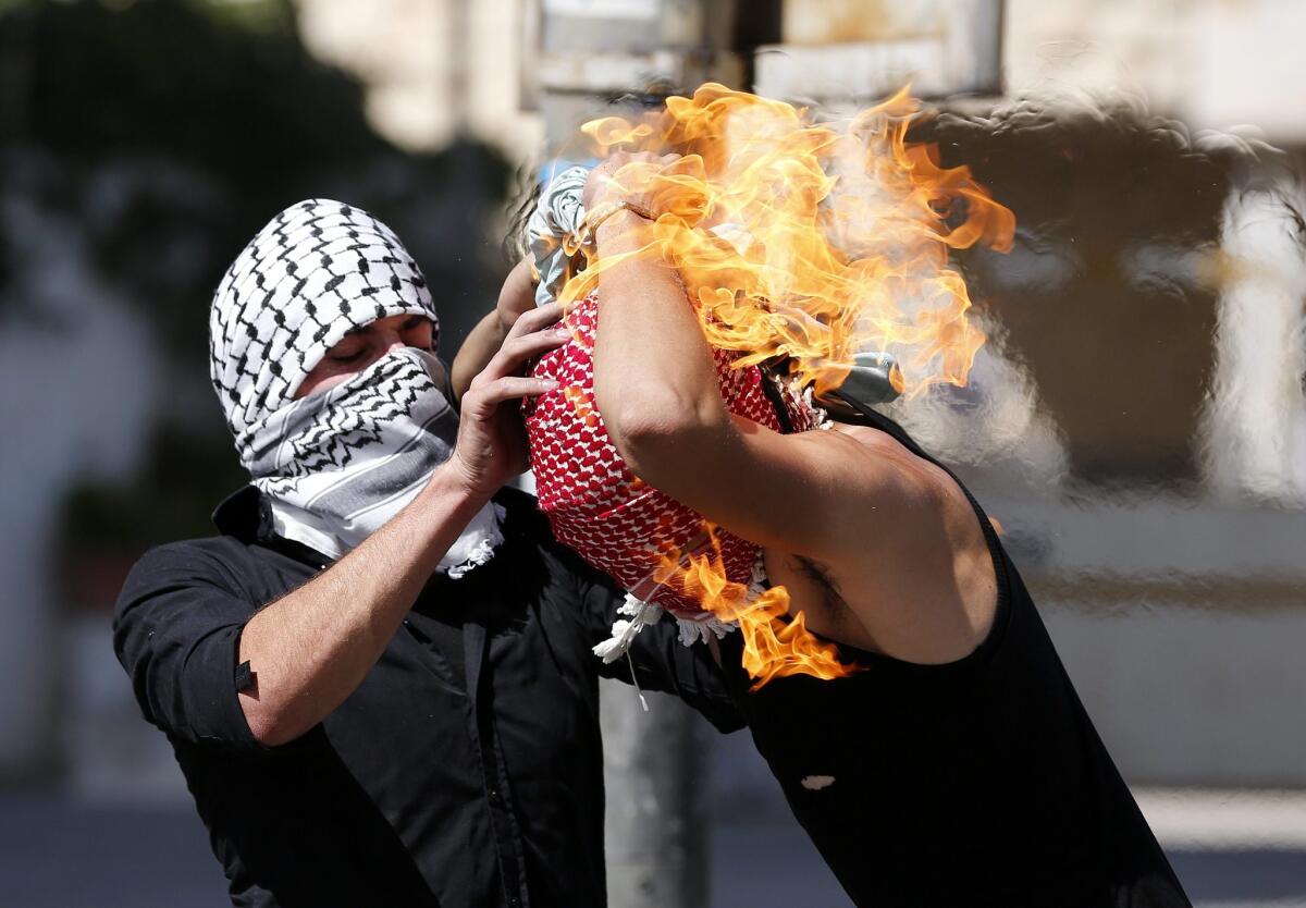A Palestinian protester sets fire to himself as he throws a molotov cocktail during clashes with the members of the Israeli armed forces in the West Bank city of Hebron.