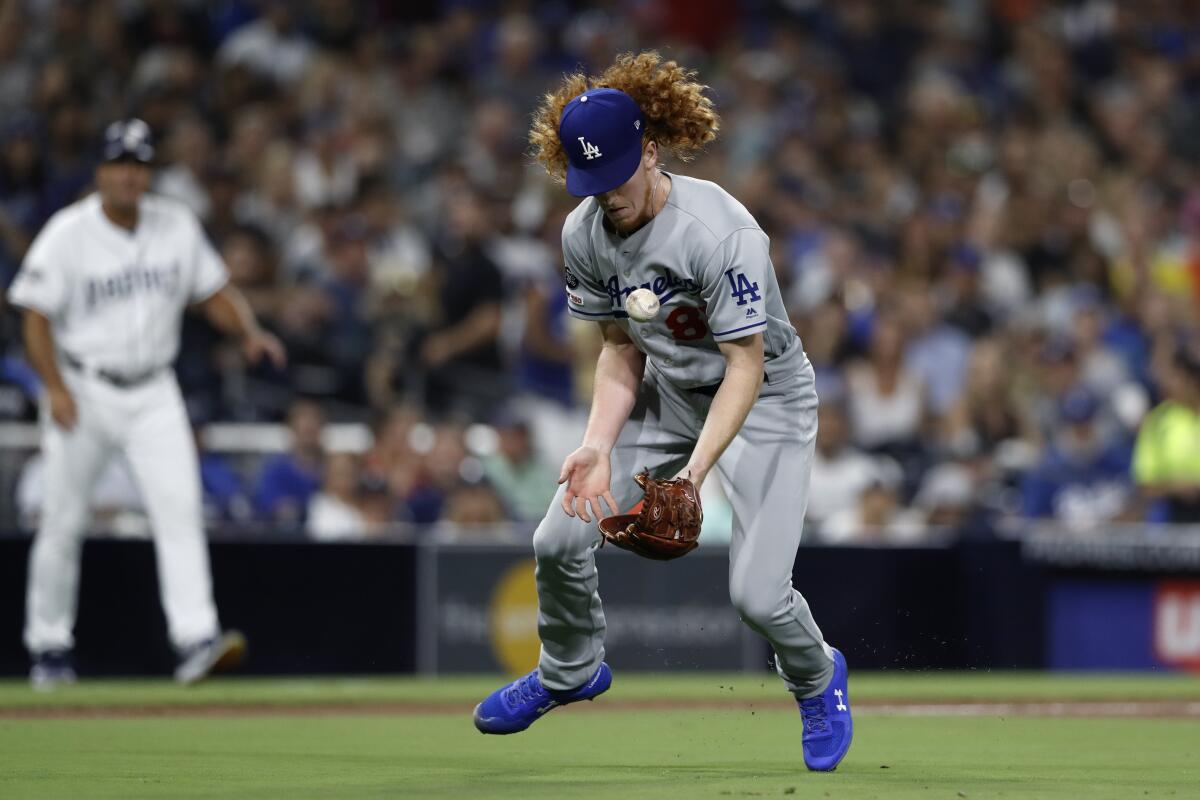 Dodgers pitcher Dustin May bobbles a ground ball before throwing out the Padres' Josh Naylor at first during the fourth inning of Monday's game.