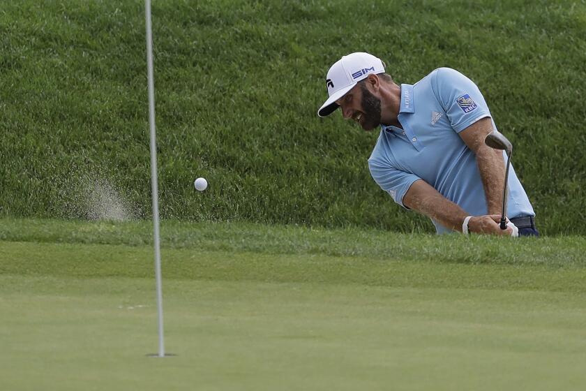 Dustin Johnson hits out of a bunker onto the 16th green during the final round of the Travelers Championship.