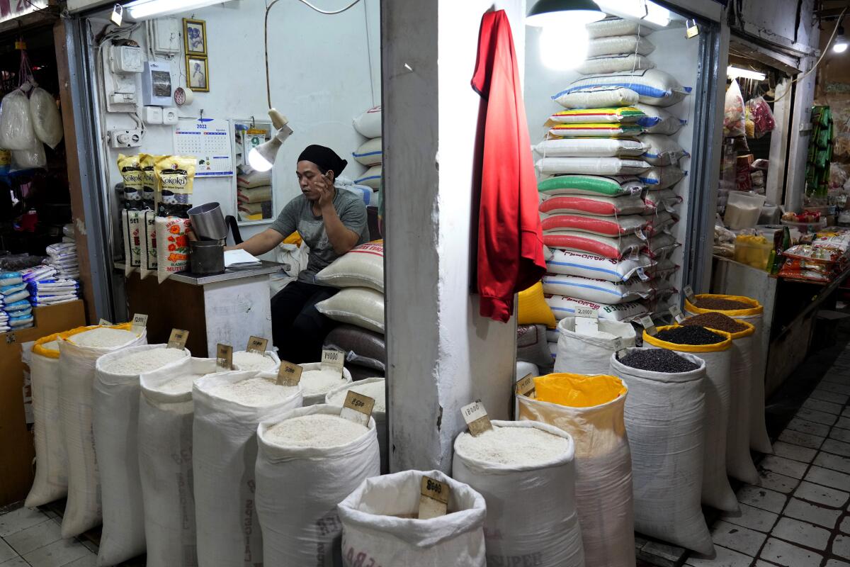 Una vendedora espera a los clientes en su puesto de arroz y otros granos 