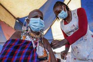 FILE - A Maasai woman receives the AstraZeneca coronavirus vaccine at a clinic in Kimana, southern Kenya on Aug. 28, 2021. The World Health Organization said Thursday, April 14, 2022 that the number of coronavirus cases and deaths in Africa have dropped to their lowest levels since the pandemic began, marking the longest decline yet seen in the disease. (AP Photo/Brian Inganga, File)