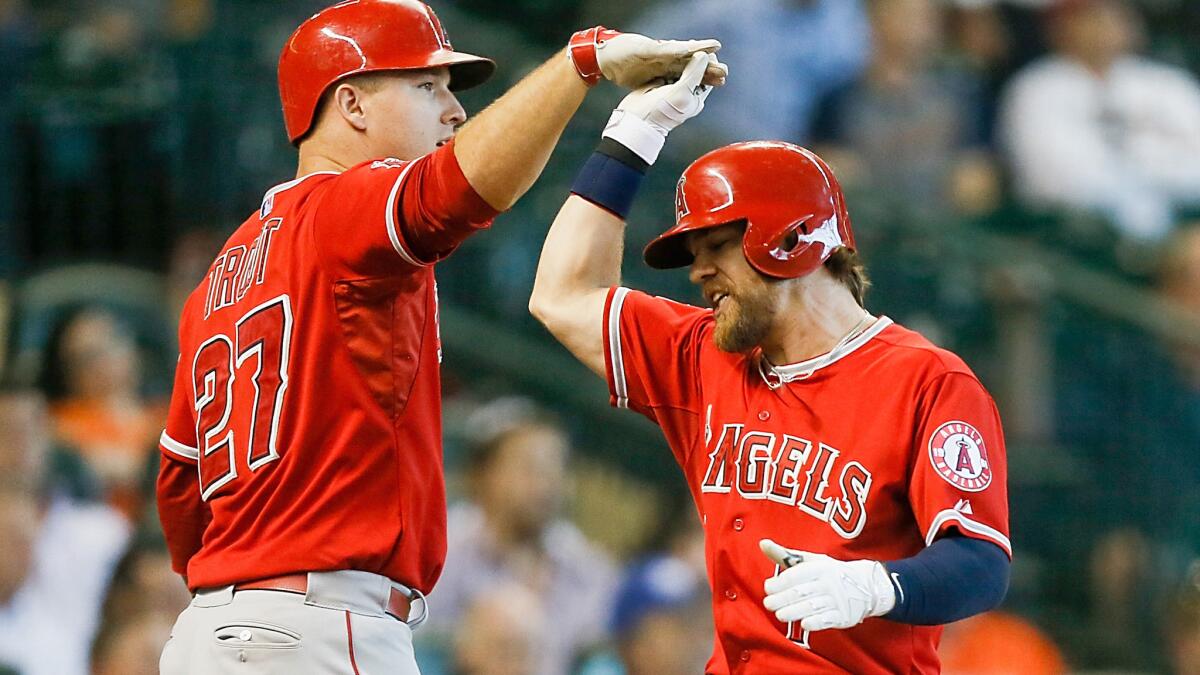 Angels left fielder Collin Cowgill receives a high-five from center fielder Mike Trout (27) after scoring against the Astros during a victory on Wednesday night in Houston.