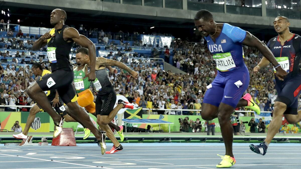 Jamaica's Usain Bolt, left, crosses the line ahead of American Justin Gatlin to win gold in the men's 100-meter final Sunday.