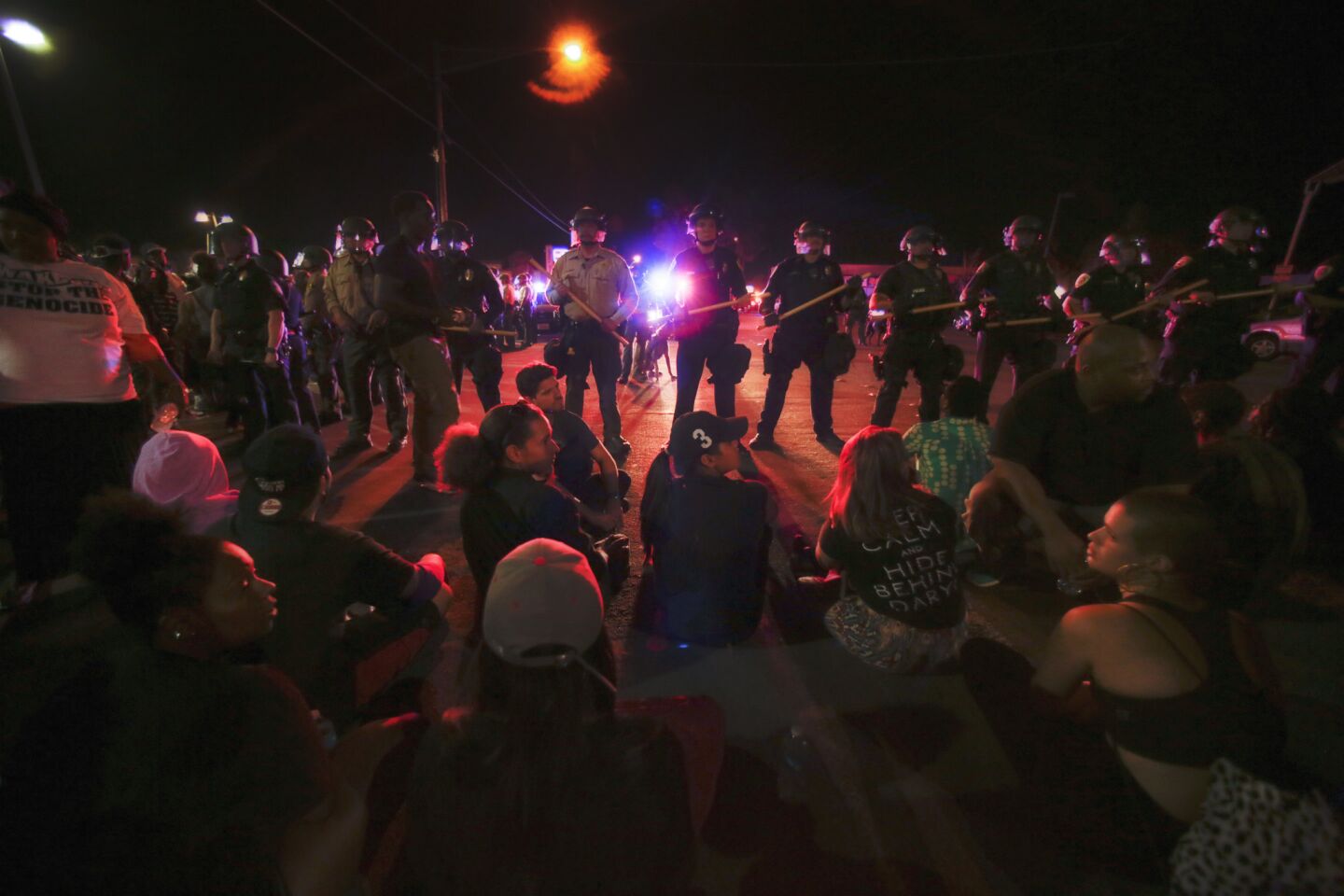 Protesters peacefully sit on Broadway in El Cajon, stopping traffic in both directions overthe death of Alfred Olango.