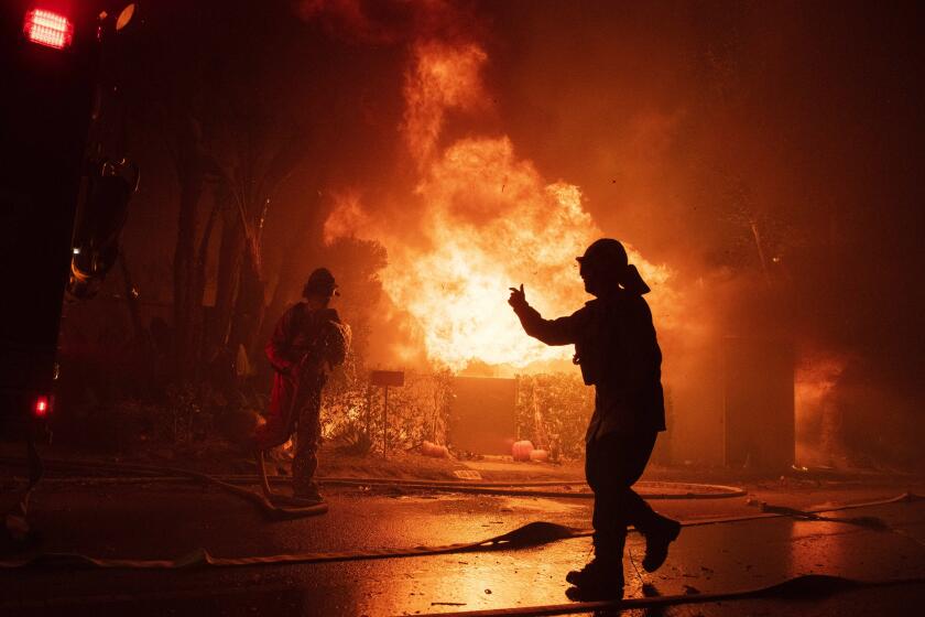 Firefighters try to save a home on Tigertail Road during the Getty fire, Monday, Oct. 28, 2019, in Los Angeles, Calif. (AP Photo/ Christian Monterrosa)