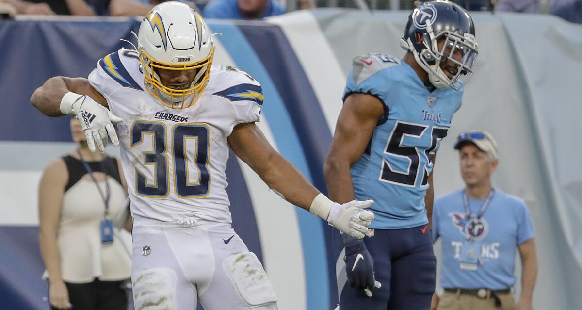  Chargers running back Austin Ekeler (30) celebrates a touchdown against Tennessee with an air guitar move.