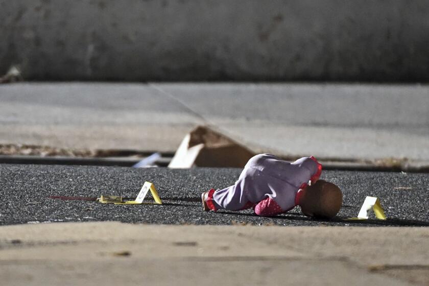 In this Monday, Nov. 19, 2018, photo, a child's doll lays next to police shooting evidence tags, as Baltimore City Police officers investigate the scene of a shooting at the 1000 block of McKean Avenue in Baltimore, where authorities say a 5-year-old girl was shot and wounded. The child l was to the hospital and immediately taken into surgery. Police were told she was alert and able to talk to doctors (Kenneth K. Lam/The Baltimore Sun via AP)