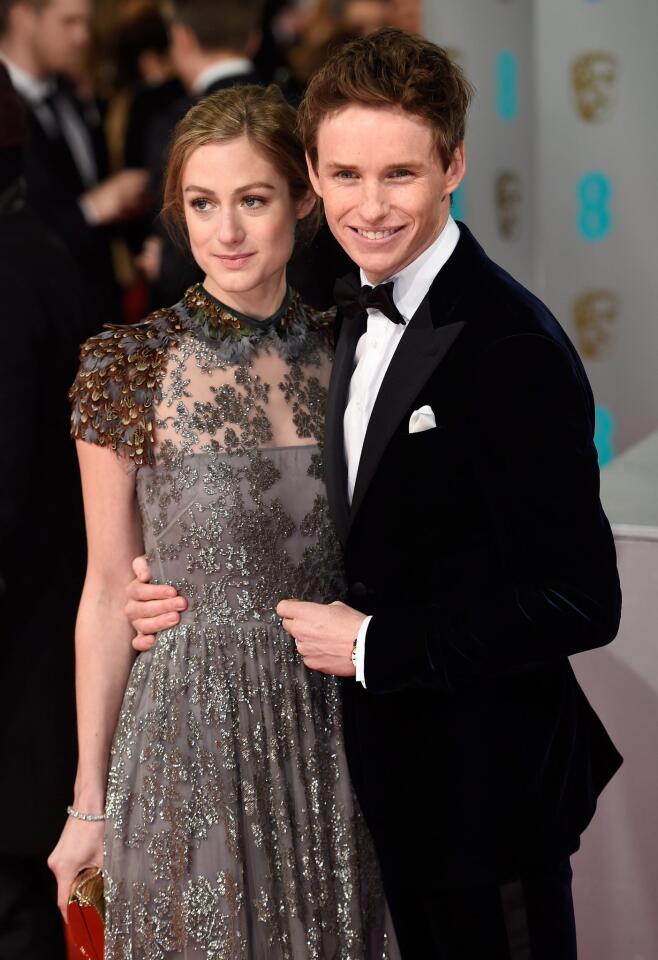 British actor Eddie Redmayne (R) and wife Hannah Bagshawe (L) arrive on the red carpet for the 2015 British Academy Film Awards ceremony at The Royal Opera House in London on February 8, 2015.
