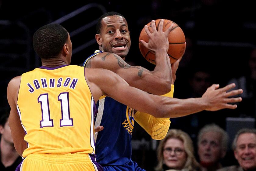 Lakers forward Wesley Johnson applies defensive pressure against Warriors forward Andre Iguodala in the first half Friday night at Staples Center.