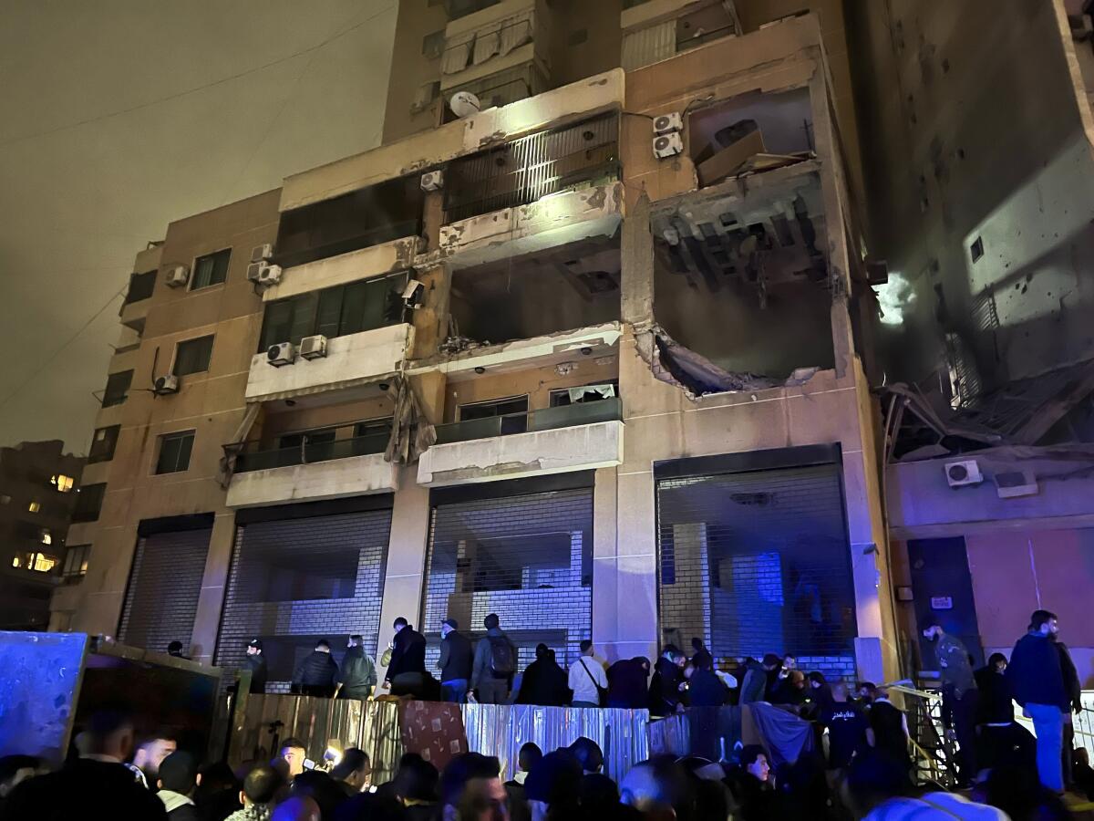 Varias personas afuera de un edificio tras una explosión en el sur de Beirut, Líbano, 