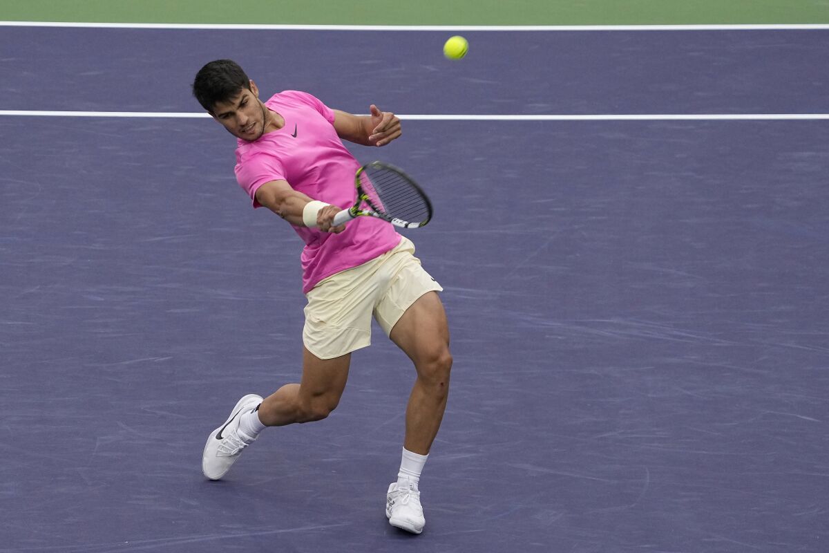 Carlos Alcaraz hits a return during his semifinal win over Jannik Sinner.