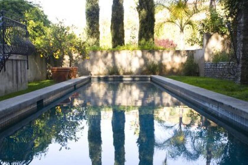 Italian cypress trees are often used as screens between properties; the ones pictured here in a Pasadena garden also provide a nice reflection in the pool. For a reader in the Antelope Valley, the hurdle to healthy trees might be in the soil.