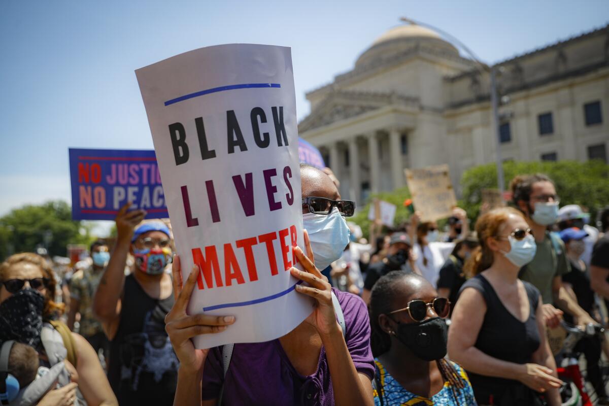 Protesters wear protective masks June 19 as they march after a Juneteenth rally outside the Brooklyn Museum in New York.
