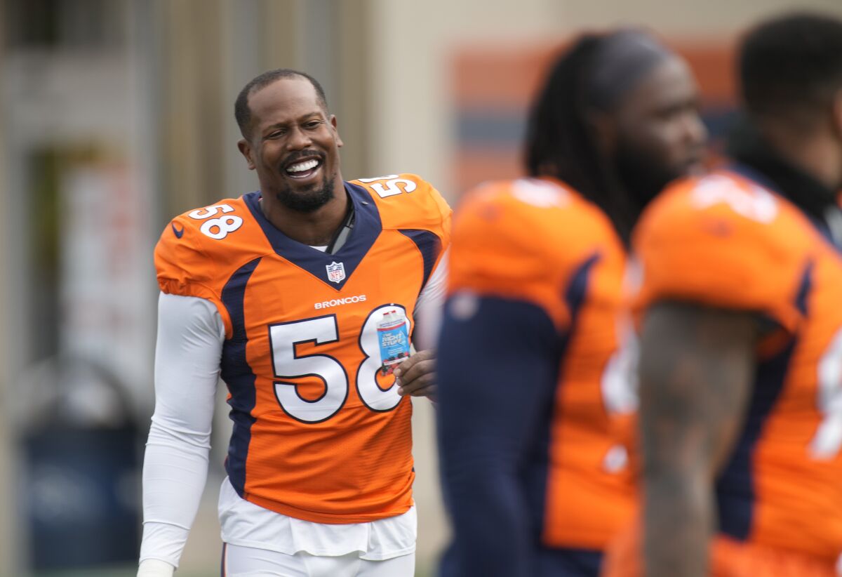 Denver Broncos outside linebacker Von Miller, left, jokes with teammates as they take part in drills at an NFL football training camp Tuesday, Aug. 3, 2021, at team headquarters in Englewood, Colo. (AP Photo/David Zalubowski)