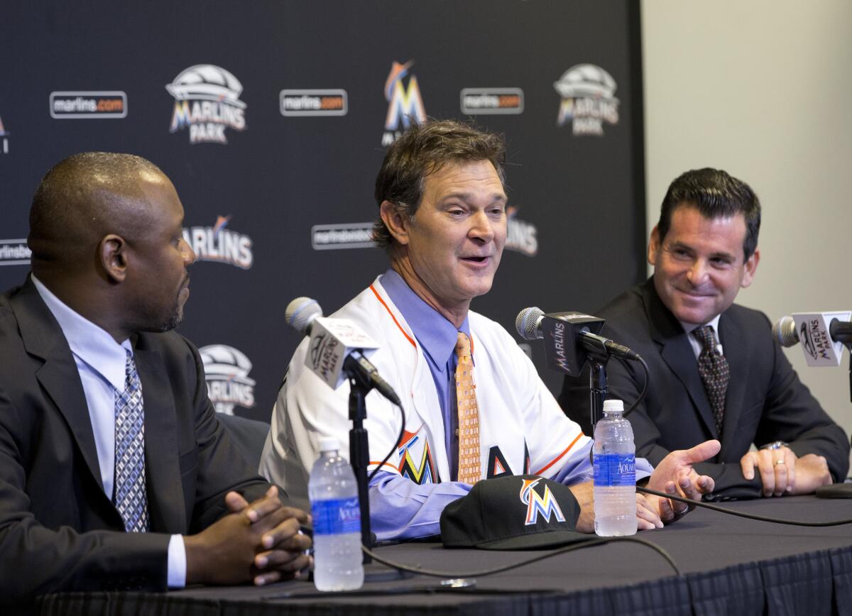 Don Mattingly, center, speaks to members of the media accompanied by Marlins President of Baseball Operation Michael Hill, left, and team president David Samson, right, after Mattingly was introduced as the Marlins Manager.