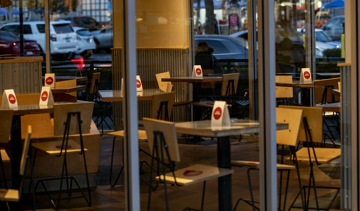 Signs are placed on tables that are off-limits to diners inside a Chipotle restaurant in Riverside.
