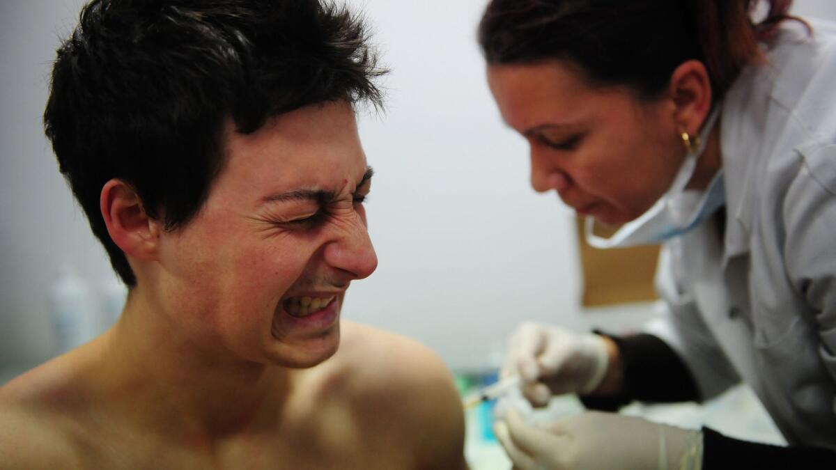 A Romanian gets vaccinated against swine flu in an underground pedestrian passage at University Square in Bucharest on Jan. 11, 2010.