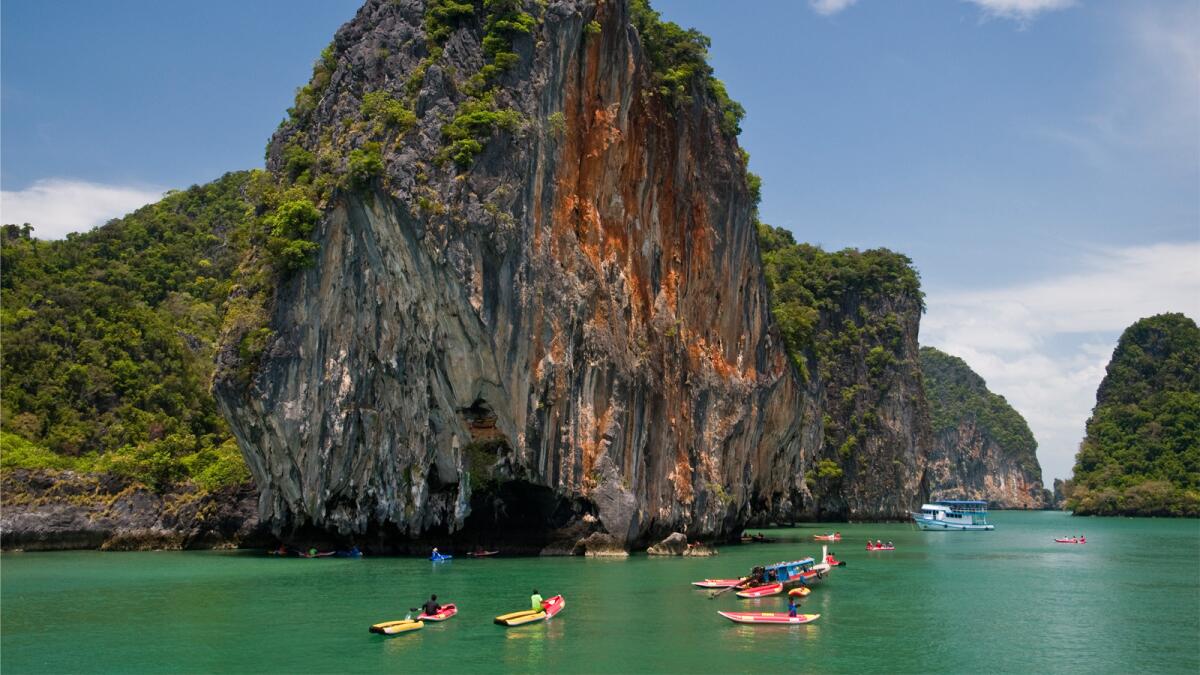 Kayakers make their way around parts of Phang Nga Bay in Thailand.