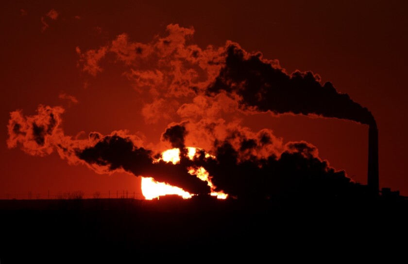 Steam from the Jeffrey Energy Center coal-fired power plant is silhouetted against the setting sun near St. Marys, Kansas.