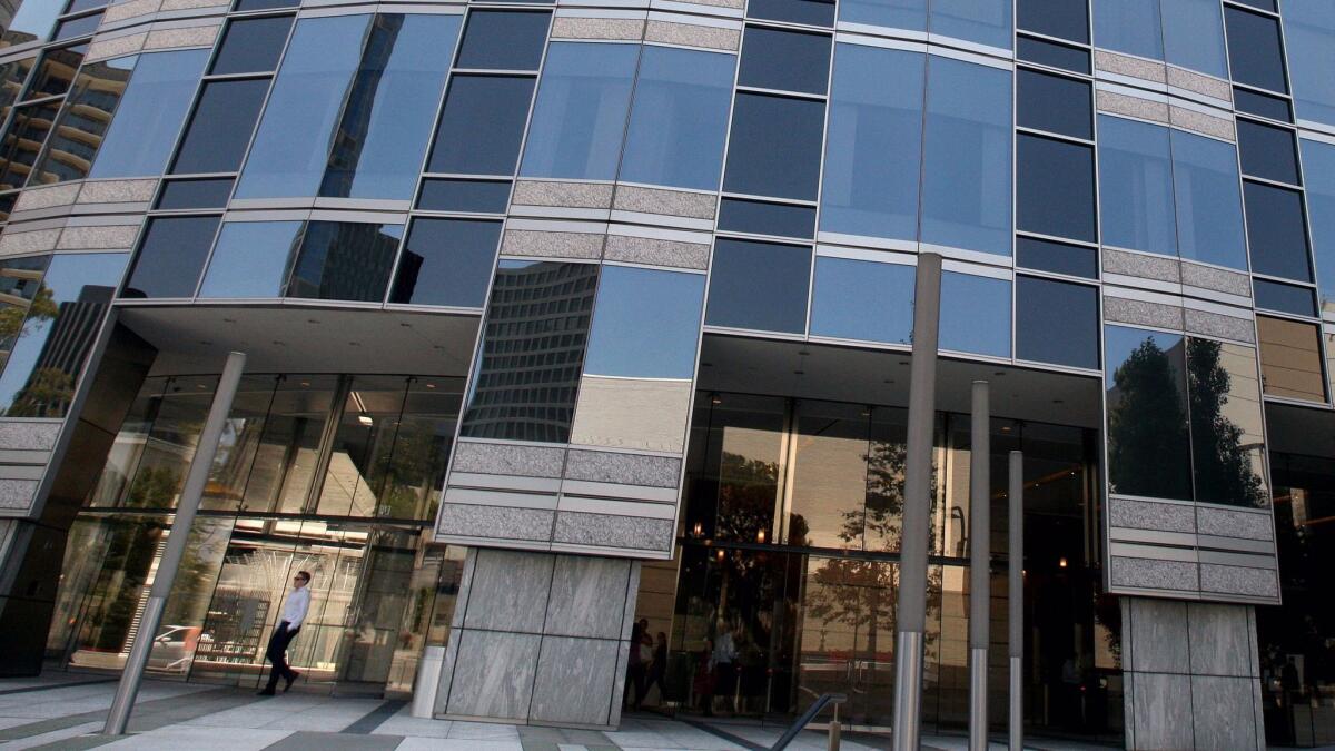 Advocacy groups want to block Pacific Western Bank's acquisition of another local lender unless the terms of the deal are changed. Above, a man walks out of a Pacific Western Bank branch in L.A.