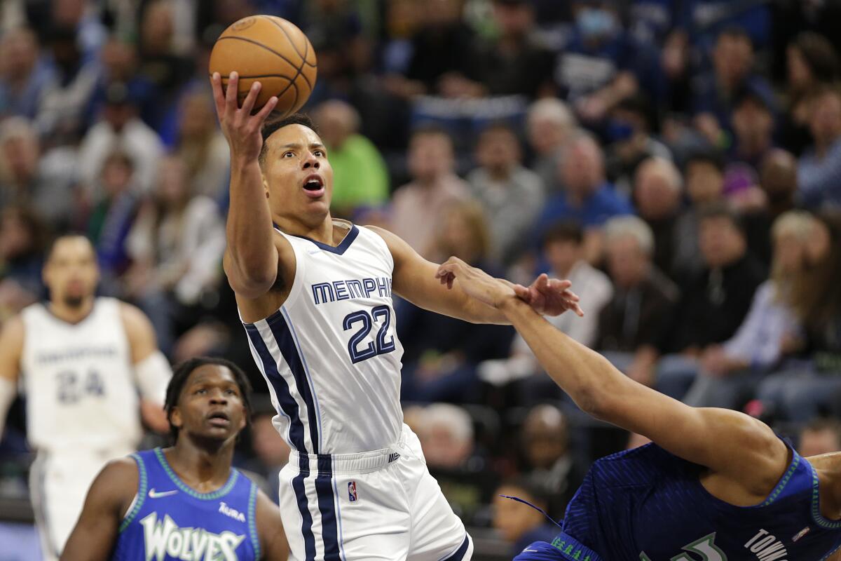 Memphis Grizzlies guard Desmond Bane shoots as Minnesota Timberwolves center Karl-Anthony Towns defends.