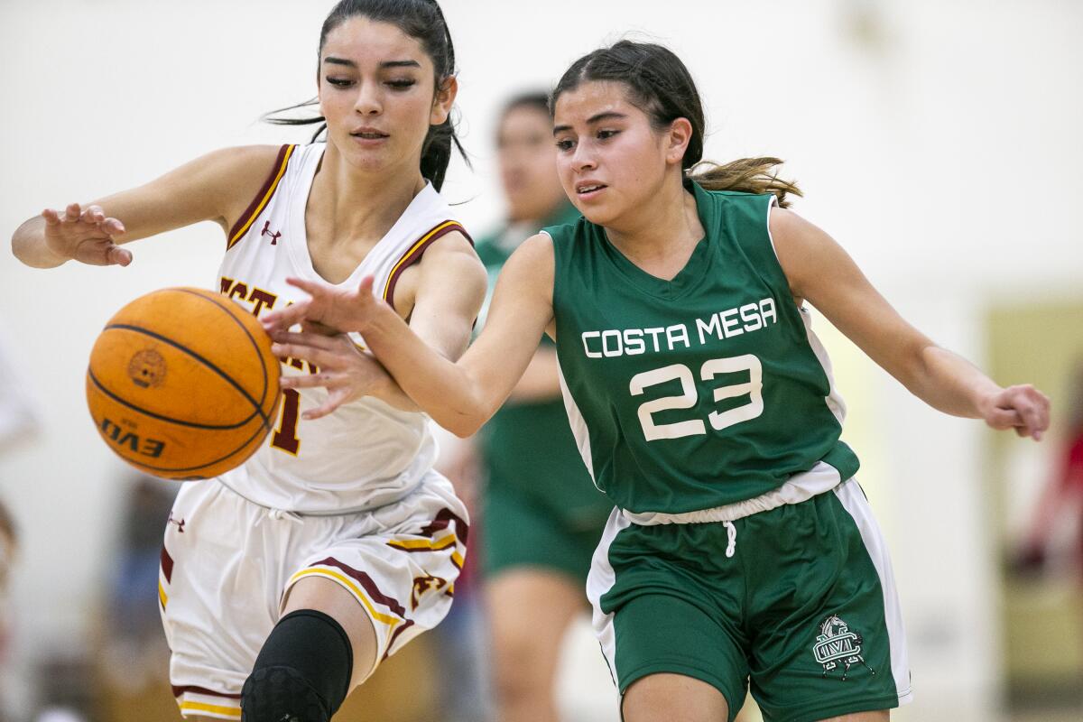 Costa Mesa's Myah Martinez battles Estancia's Andrea Meza for the ball during the Battle for the Bell game.