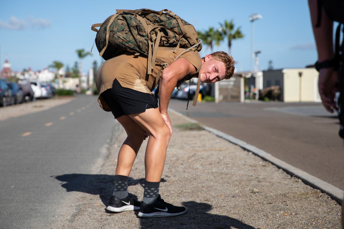 Air Force ROTC cadet Hayden Butchko rests after participating in the 13-mile ruck march 