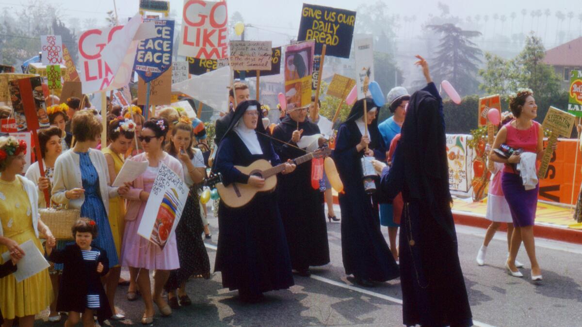 Nuns lead a procession featuring colorful handmade signs.