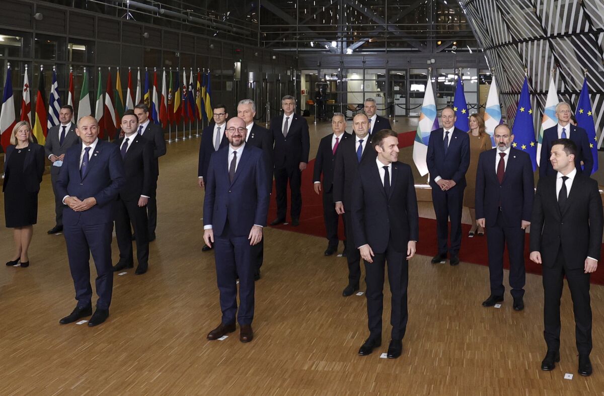 French President Emmanuel Macron, front second right, speaks with Ukraine's President Volodymyr Zelenskyy, front right, during a group photo of EU leaders and Eastern Partnership countries at an Eastern Partnership Summit in Brussels, Wednesday, Dec. 15, 2021. European Union leaders meet with partner nations on its eastern borders on Wednesday, with the Russian military buildup on Ukraine's border as the main point of focus. (AP Photo/Olivier Matthys)