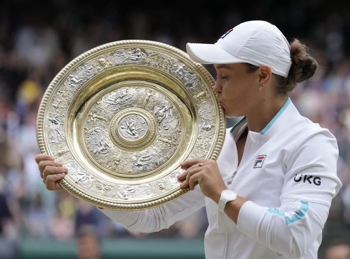 Australia's Ashleigh Barty poses with the winners trophy for the media after winning the women's singles final after defeating the Czech Republic's Karolina Pliskova on day twelve of the Wimbledon Tennis Championships in London, Saturday, July 10, 2021. (AP Photo/Kirsty Wigglesworth)